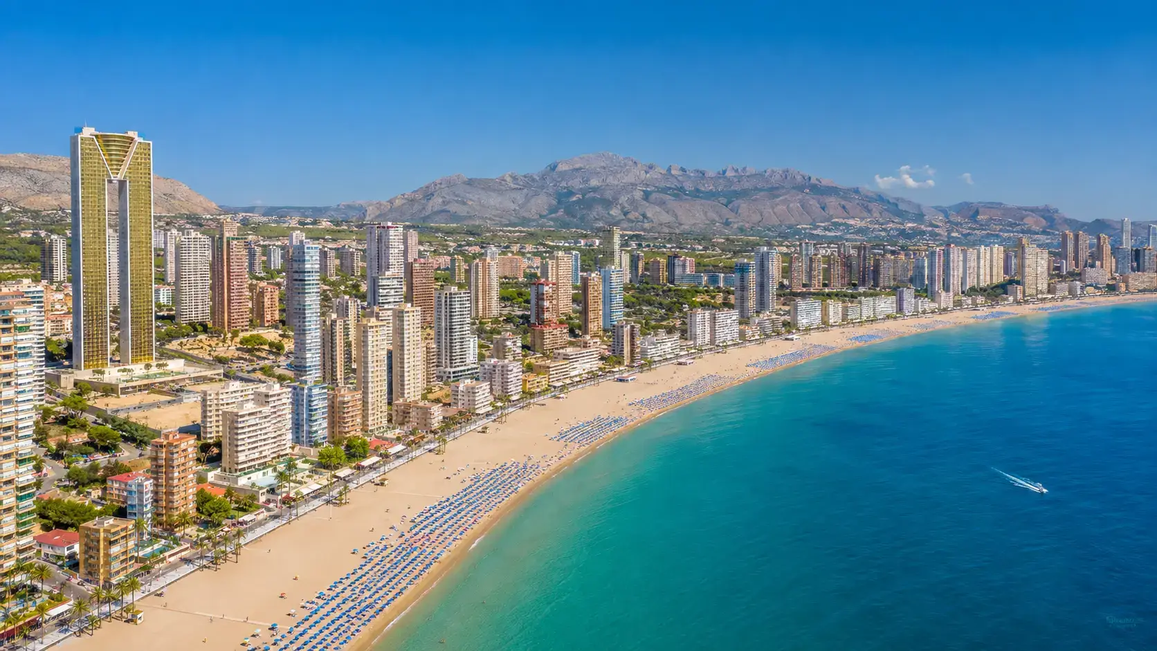 The iconic skyline and sandy beach of Benidorm resort, a prime destination for visitors booking private taxi services from Alicante airport.