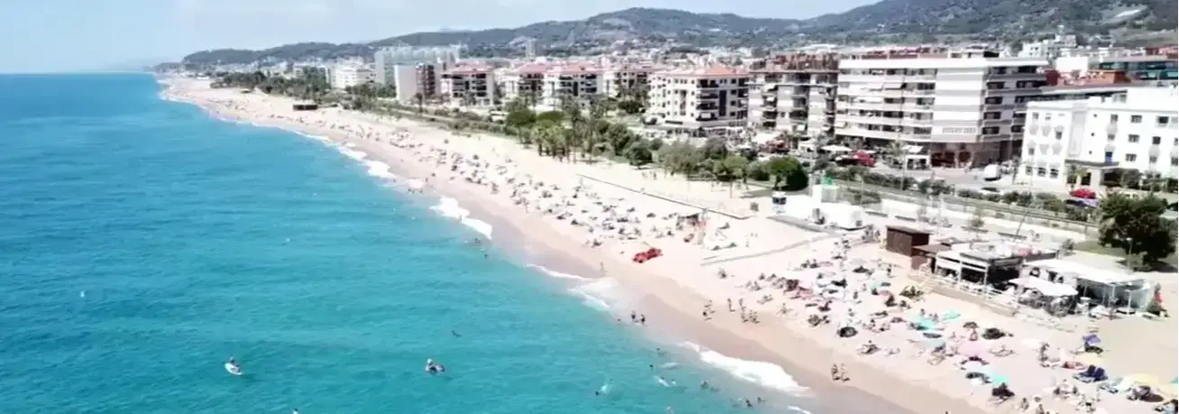 The wide golden sand beachfront of Pineda de Mar, a peaceful holiday resort destination served by Cheap Taxis direct private airport shuttle services from Girona Airport.