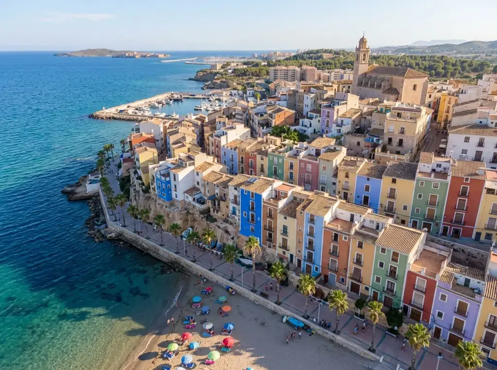 The iconic brightly colored houses along the seafront at Villajoyosa resort, a popular destination reached via private taxi services from Alicante airport.