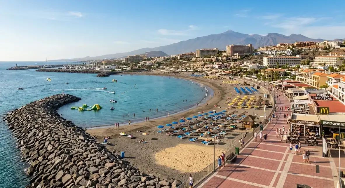 A beautiful view of the golden sand beach and beachfront hotels in Torviscas, Costa Adeje, for holidaymakers booking a cheap private airport taxi with payment directly to the driver.